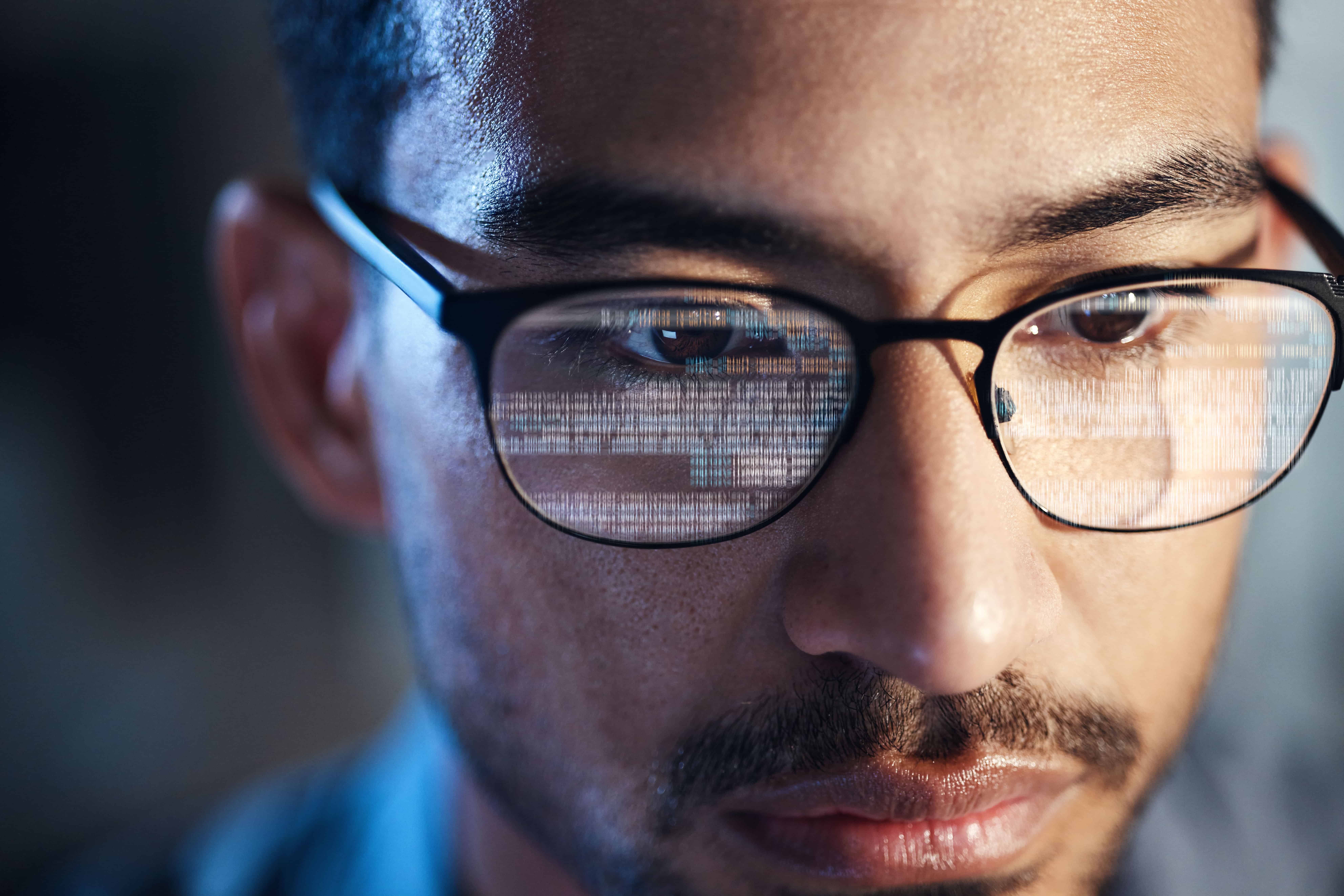 Glasses, man and reflection of code on computer working on software, programming and data_621251782-min